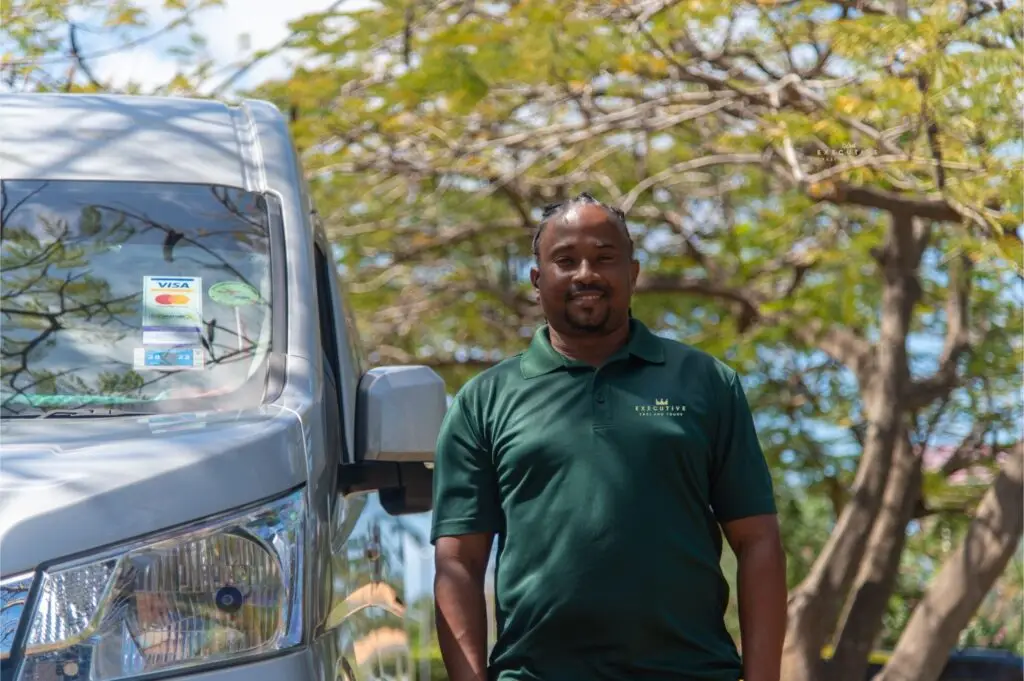 Carl, the founder of Executive Taxi and Tours Grenada, standing next used for Taxi Services